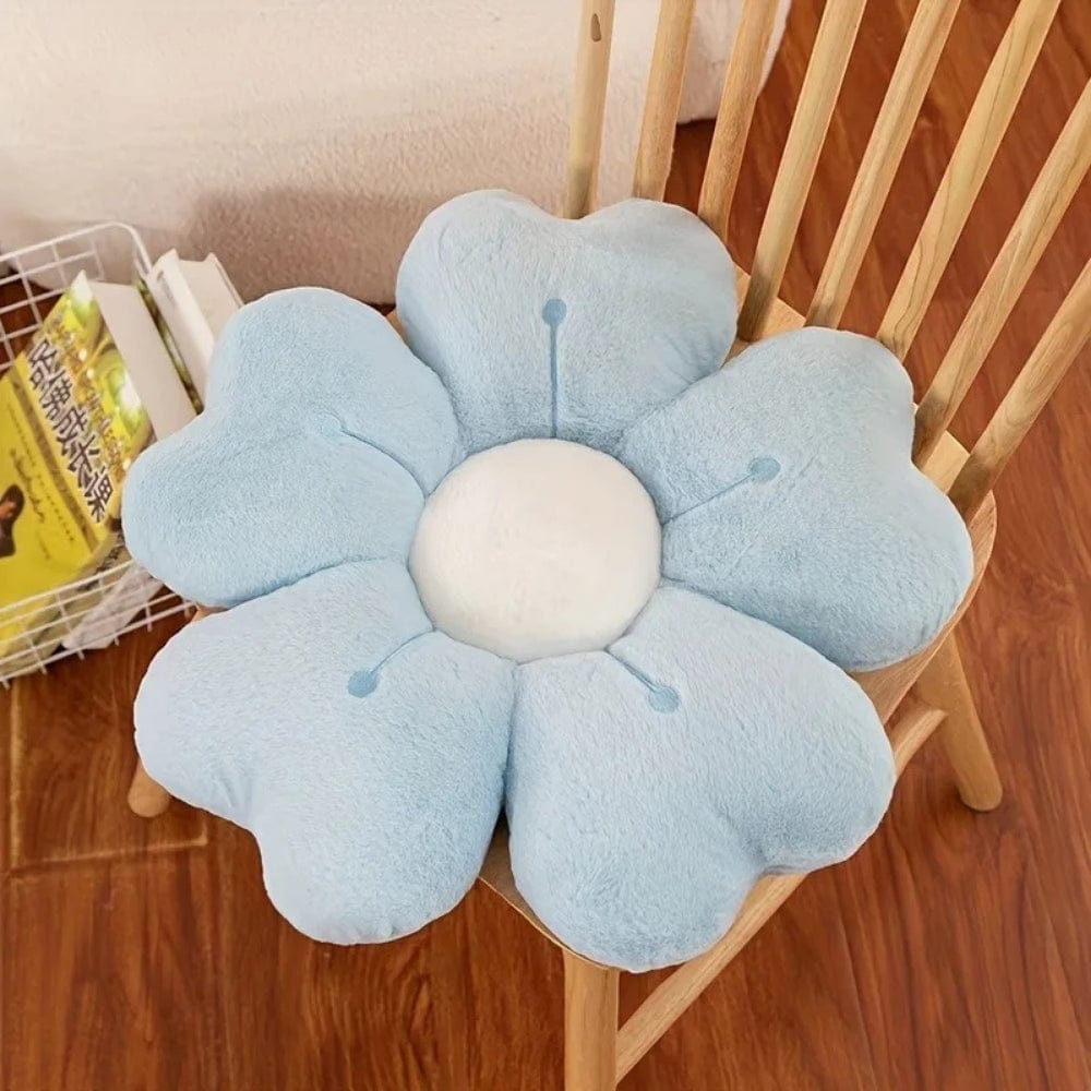 Coussin décoratif en forme de fleur, bleu pastel, placé sur une chaise en bois, ajoutant une touche ludique à l'intérieur