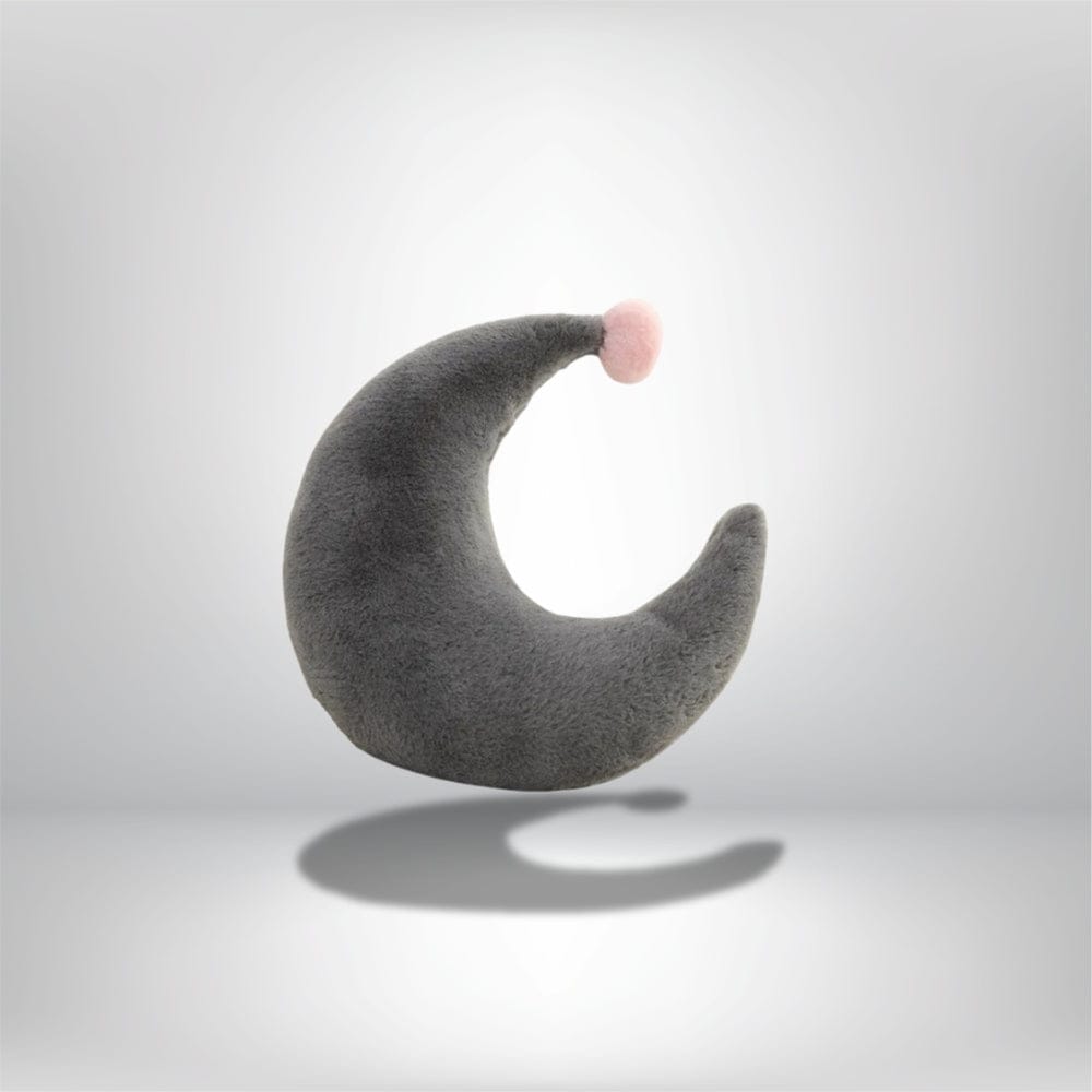 Coussin décoratif en forme de croissant gris avec un pompon rose, idéal pour un canapé moderne