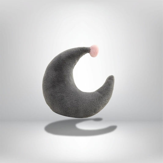Coussin décoratif en forme de croissant gris avec un pompon rose, idéal pour un canapé moderne