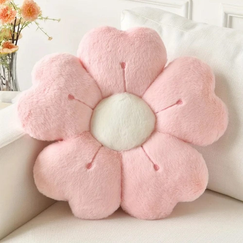 Coussin décoratif en forme de fleur, rose et moelleux, posé sur un canapé blanc