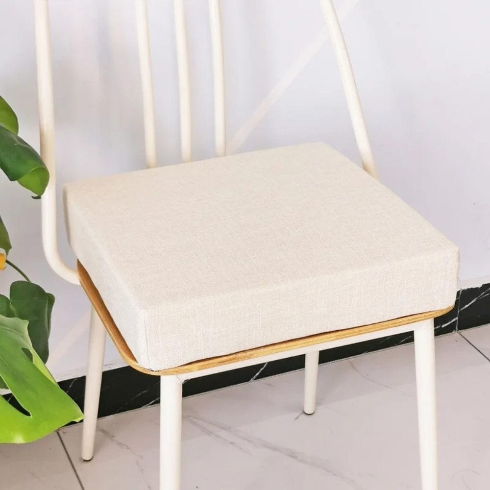 Coussin carré en tissu beige posé sur une chaise moderne, ajoutant une touche déco au salon