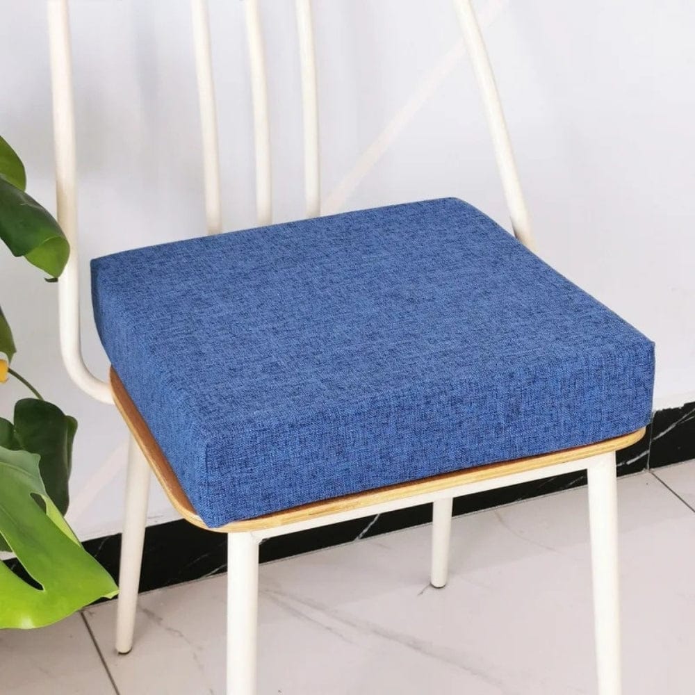 Coussin de chaise carré en tissu bleu, posé sur une chaise en bois, apportant une touche moderne au décor