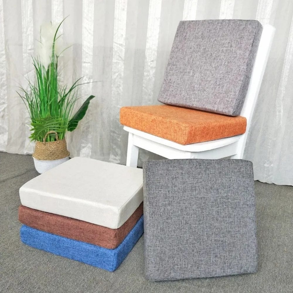 Coussins carrés en tissu, couleurs variées, posés sur une chaise blanche dans un salon lumineux