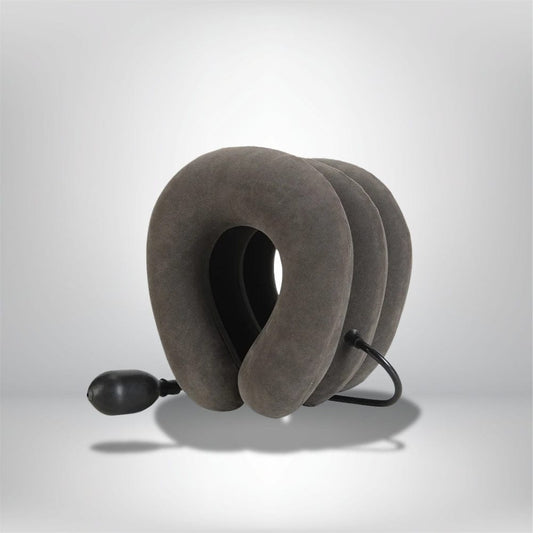 Coussin cervical gonflable en velours gris, conçu pour un soutien optimal, posé sur un fond neutre