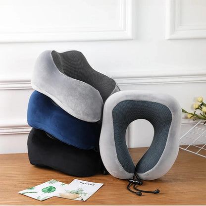 Coussins cervical en velours gris, bleu et noir, posés sur une table en bois, avec un décor minimaliste
