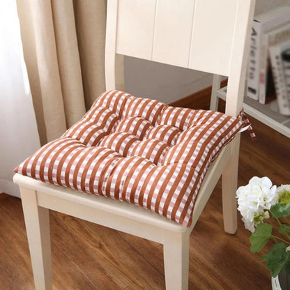 Coussin de chaise de jardin à motifs rayés marron et blanc, placé sur une chaise en bois, dans un intérieur