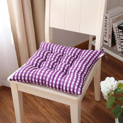 Coussin de chaise de jardin à motifs rayés violets et blancs, posé sur une chaise en bois dans un intérieur