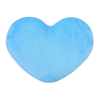 Coussin en forme de cœur, doux et bleu, posé sur un canapé, ajoutant une touche déco chaleureuse