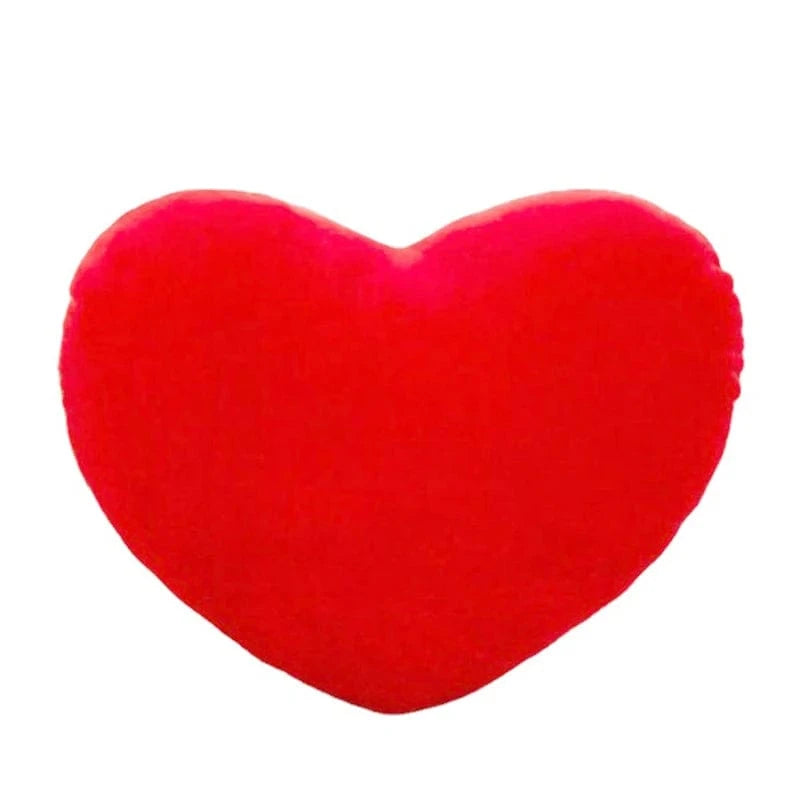 Coussin en forme de cœur rouge, doux et moelleux, posé sur un canapé moderne dans un salon chaleureux