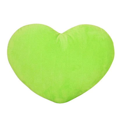 Coussin décoratif en forme de cœur, doux, de couleur verte, posé sur un canapé moderne