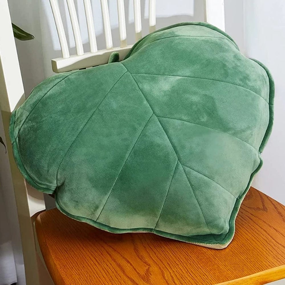 Coussin décoratif en forme de cœur, en velours vert, posé sur une chaise en bois
