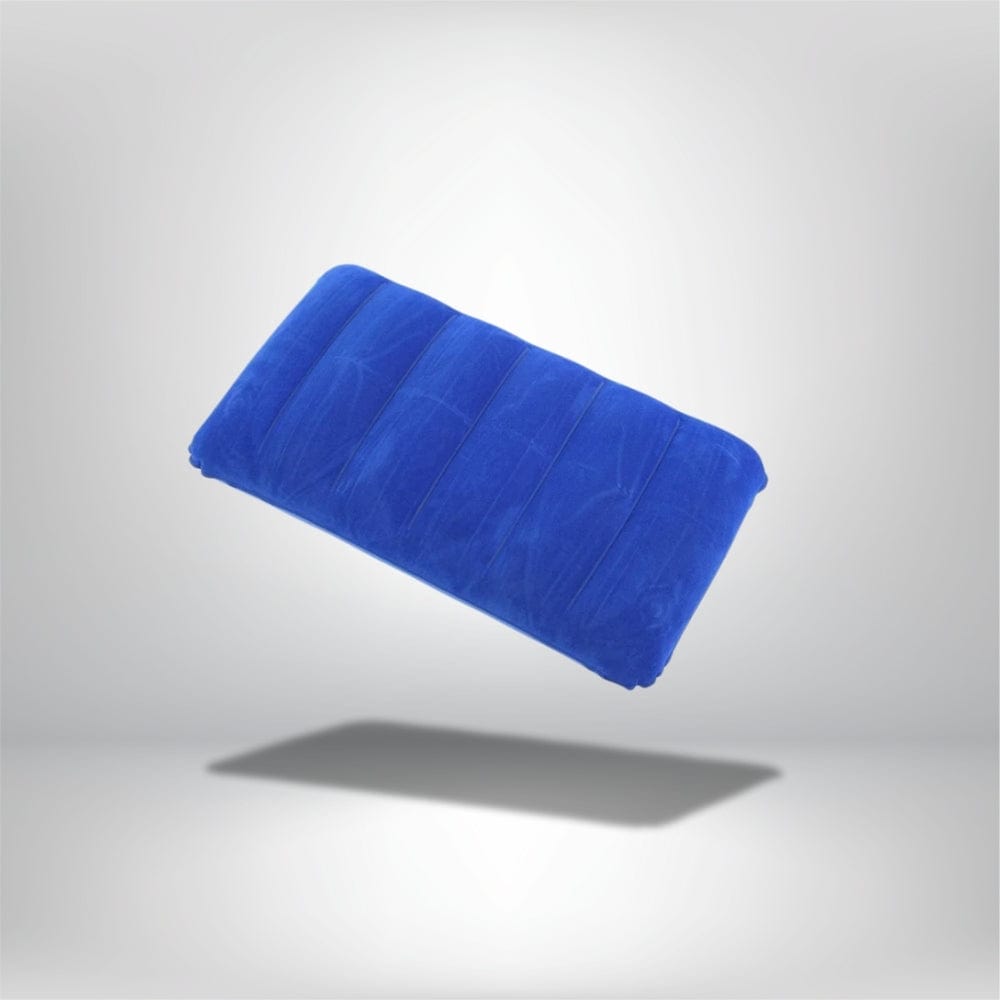 Coussin décoratif bleu en velours, légèrement rembourré, posé sur un fond neutre