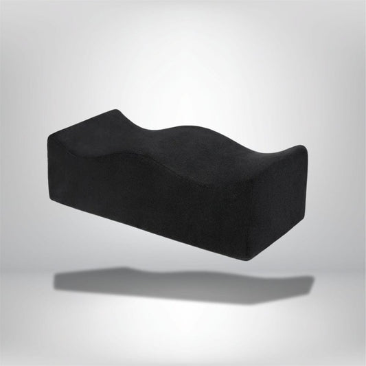 Coussin de chaise ergonomique noir avec une forme ondulée, posé sur un fond neutre