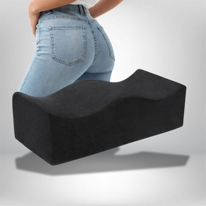 Coussin ergonomique noir en forme ondulée, posé sur un fond neutre, idéal pour un confort optimal