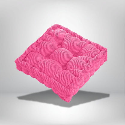 Coussin de chaise en velours côtelé rose vif, avec un design rembourré et des motifs arrondis, posé sur un fond
