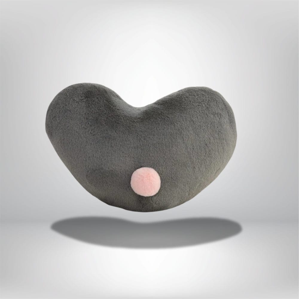 Coussin décoratif en forme de cœur gris avec un pompon rose, idéal pour un canapé moderne