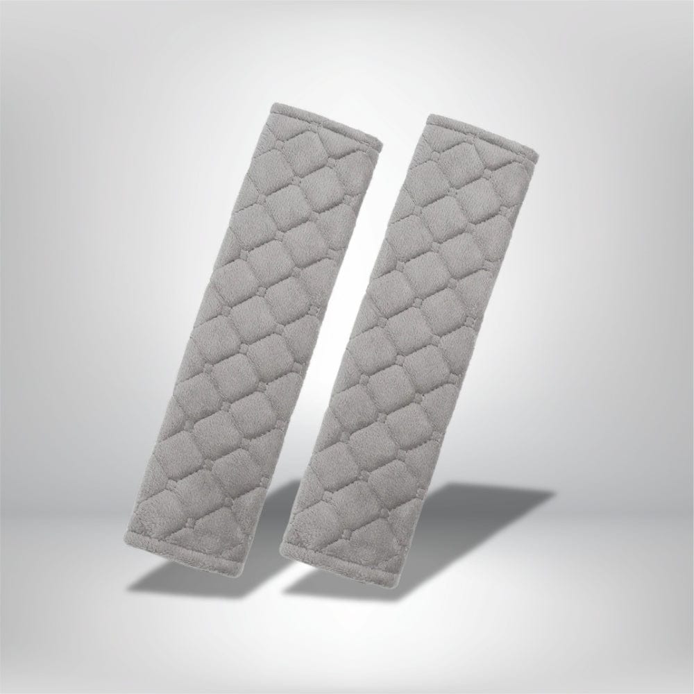 Coussins de ceinture de sécurité en tissu gris avec un motif matelassé, présentés sur un fond neutre