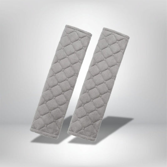 Coussins de ceinture de sécurité en tissu gris avec un motif matelassé, présentés sur un fond neutre