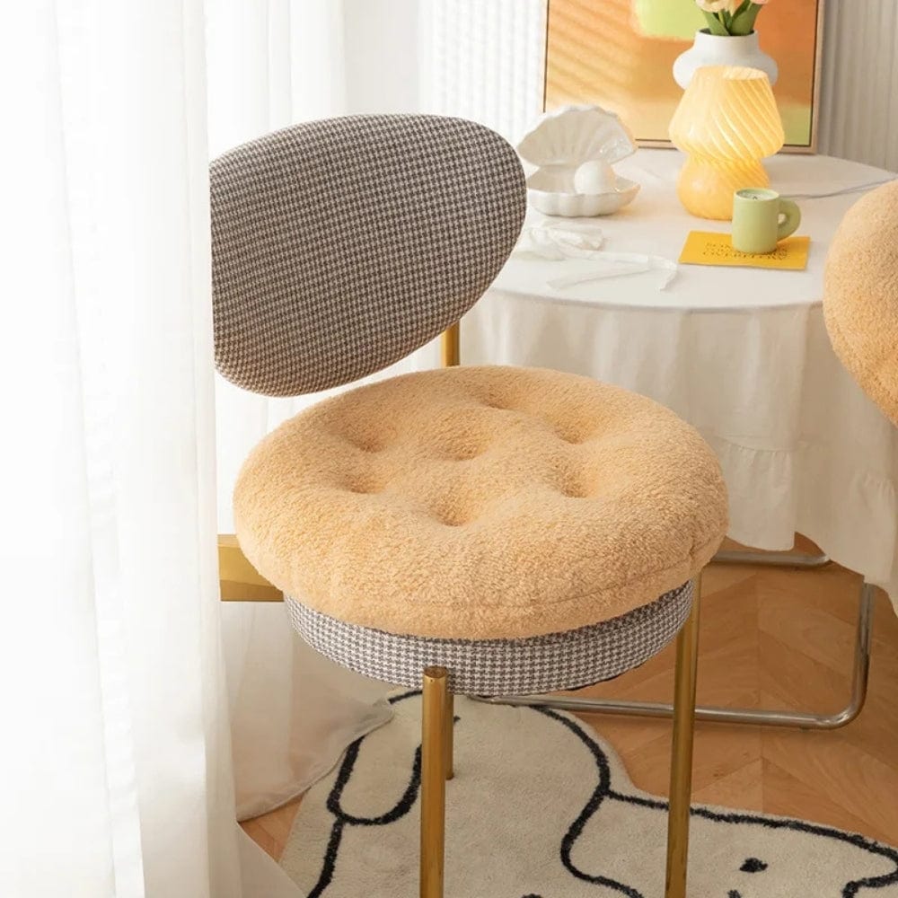 Coussin de chaise rond en tissu beige, avec un motif à carreaux gris, sur une chaise moderne dans un salon