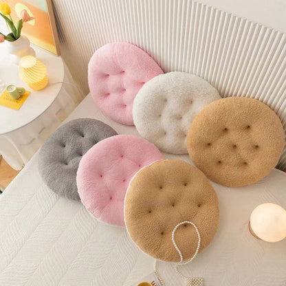Coussins ronds en tissu doux, coloris pastel, disposés sur une table, parfaits pour un décor de chaise