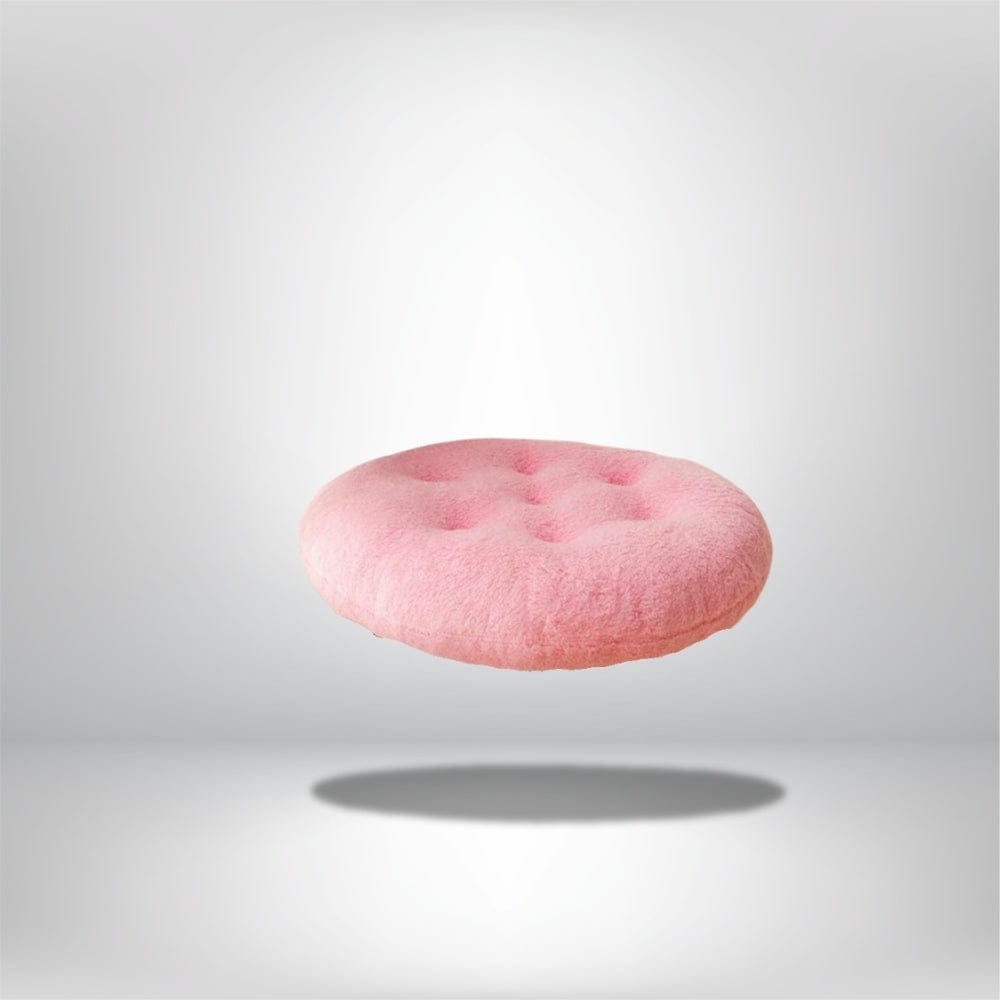 Coussin de chaise rond en velours rose, avec des boutons, flottant sur un fond neutre