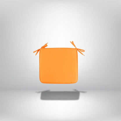 Coussin de chaise carré orange avec des liens, posé sur un fond neutre