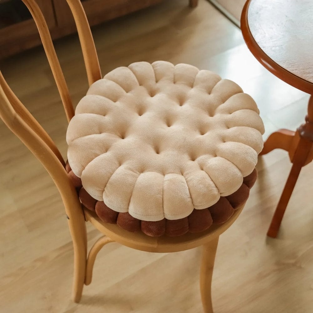 Coussin de chaise rond en velours beige et marron, avec des motifs capitonnés, posé sur une chaise en bois
