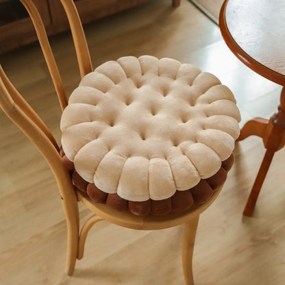 Coussin de chaise rond en velours beige et marron, avec des motifs capitonnés, posé sur une chaise en bois
