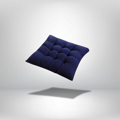 Coussin de chaise épais en velours bleu marine avec un motif matelassé, posé sur un fond neutre