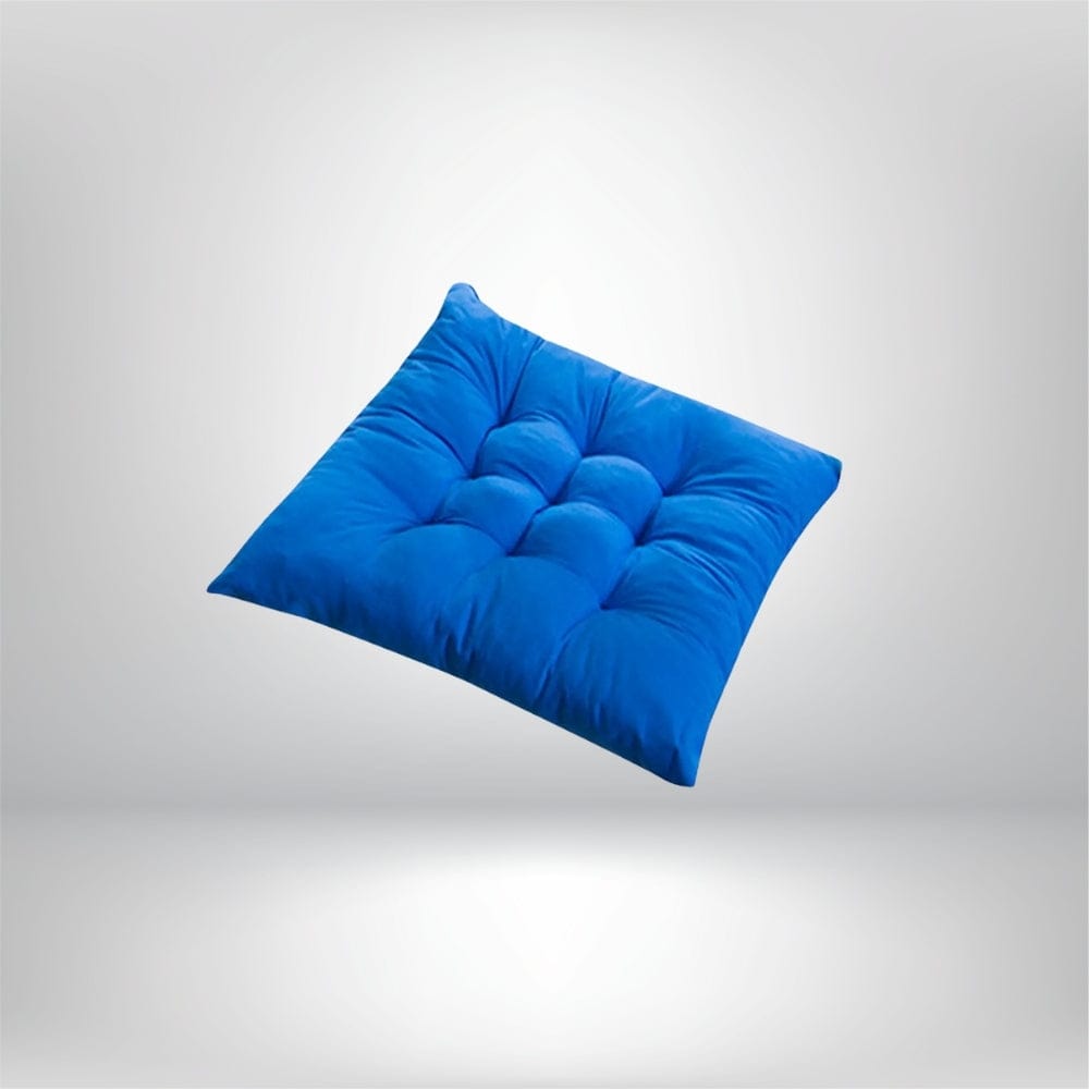 Coussin de chaise épais en velours bleu, avec des coutures matelassées, posé sur un fond neutre