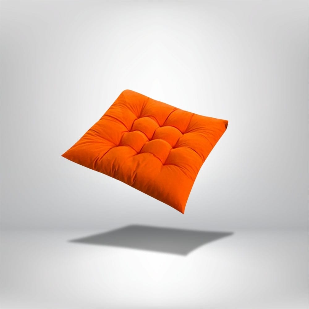 Coussin de chaise épais en velours orange, avec des motifs matelassés, flottant sur un fond neutre