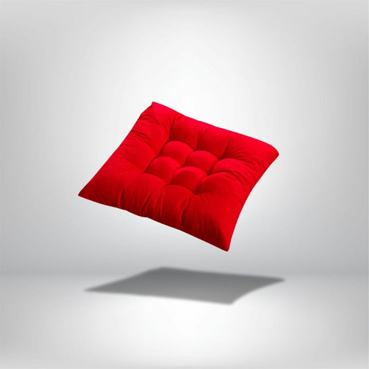 Coussin de chaise épais en velours rouge, avec un motif matelassé, posé sur un fond neutre