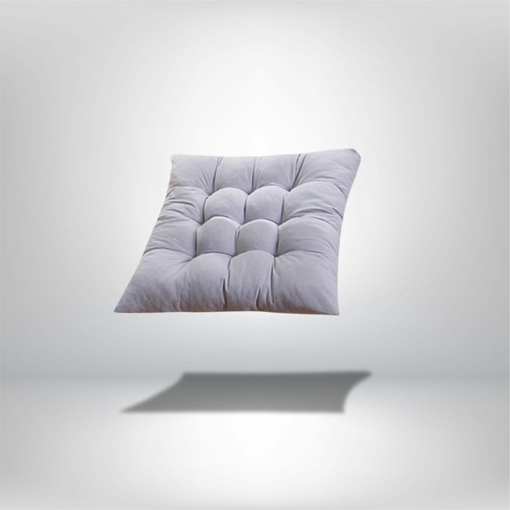 Coussin de chaise épais en tissu gris clair avec un motif matelassé, posé sur un fond neutre