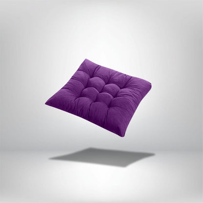 Coussin de chaise épais en velours violet avec des coutures matelassées, posé sur un fond neutre