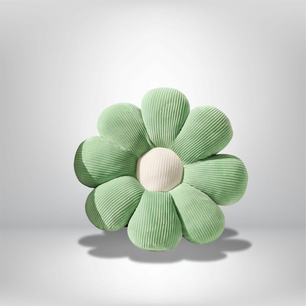 Coussin déco en forme de fleur, vert pastel avec des pétales striés, posé sur une surface neutre