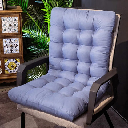 Coussin de chaise bleu en tissu matelassé, posé sur une chaise noire dans un décor moderne avec des plantes