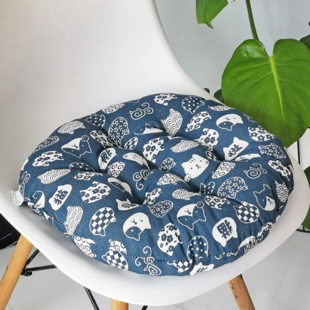 Coussin de chaise rond en tissu bleu avec motifs blancs d'animaux, posé sur une chaise moderne dans un salon