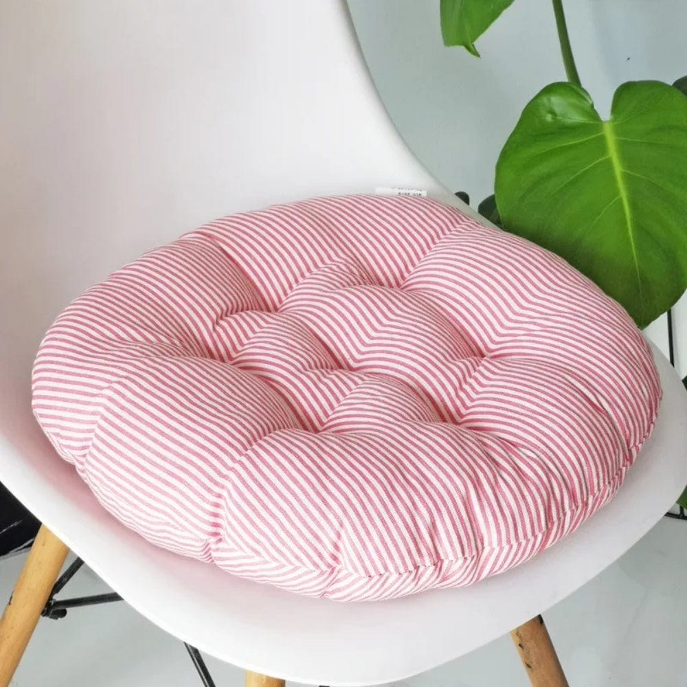 Coussin de chaise rond en tissu à rayures roses, posé sur une chaise blanche moderne, apportant une touche déco