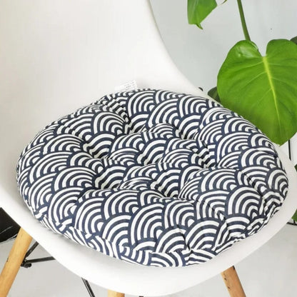 Coussin de chaise rond avec un motif en vagues bleues et blanches, posé sur une chaise moderne