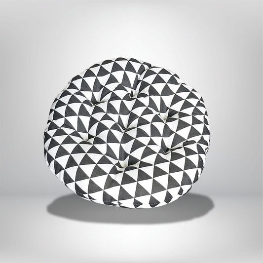Coussin de chaise rond en tissu noir et blanc avec un motif géométrique en triangles, posé sur un fond neutre