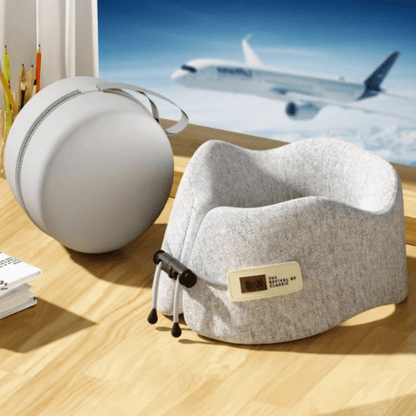 Coussin de cou en tissu gris, posé sur un bureau en bois, avec un design ergonomique pour le voyage