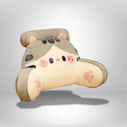 Coussin de lecture en forme de chat, aux couleurs beige et gris, posé sur un lit, ajoutant une touche kawaii