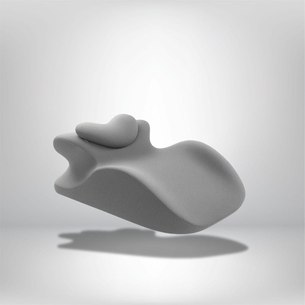 Coussin de lecture en forme ondulée, en tissu gris, posé sur un fond neutre, idéal pour un lit moderne