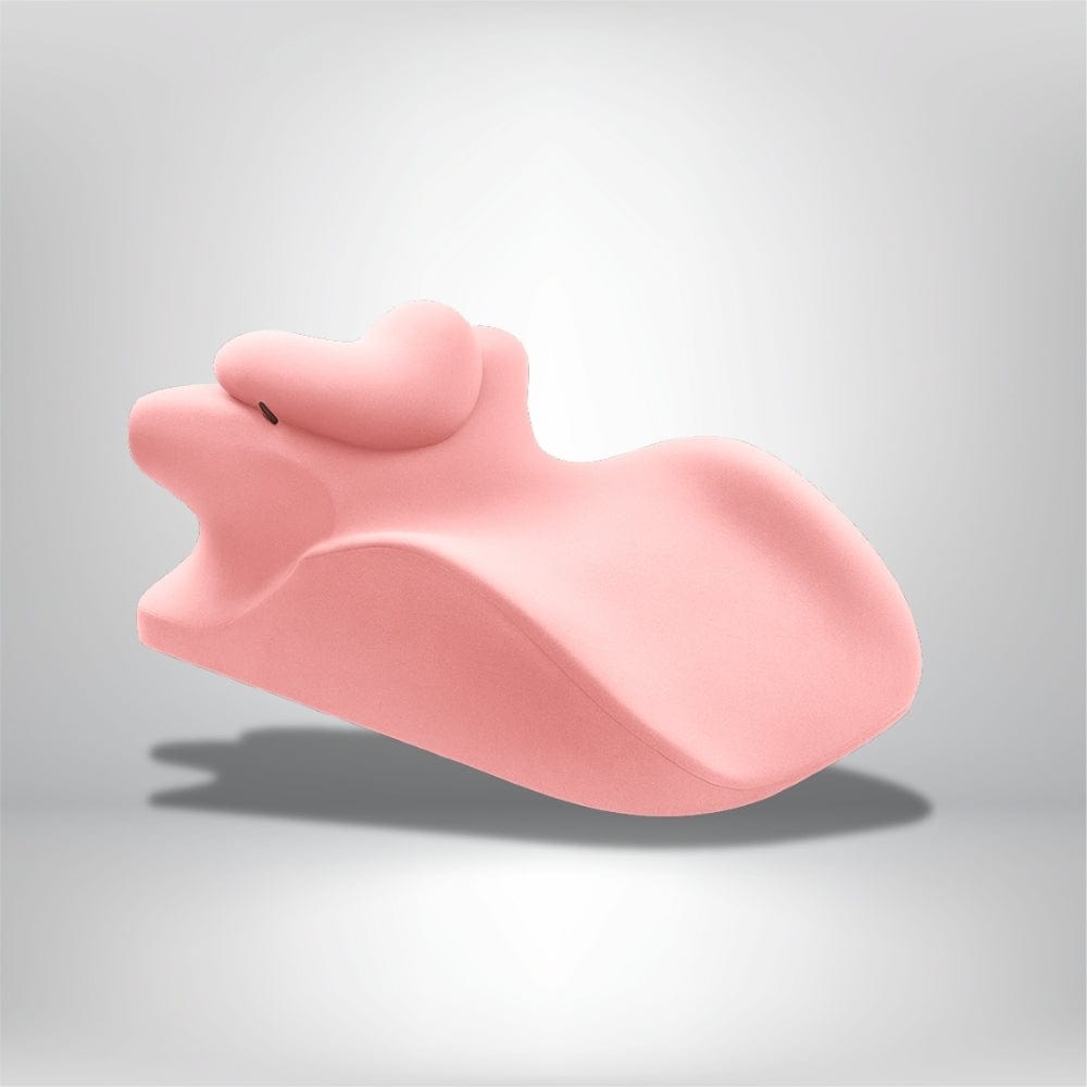 Coussin de lecture rose en forme originale, posé sur un lit moderne, ajoutant une touche déco ludique