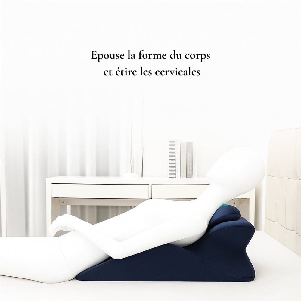 Coussin de lecture en forme ergonomique, couleur bleu marine, posé sur un lit moderne avec un décor épuré