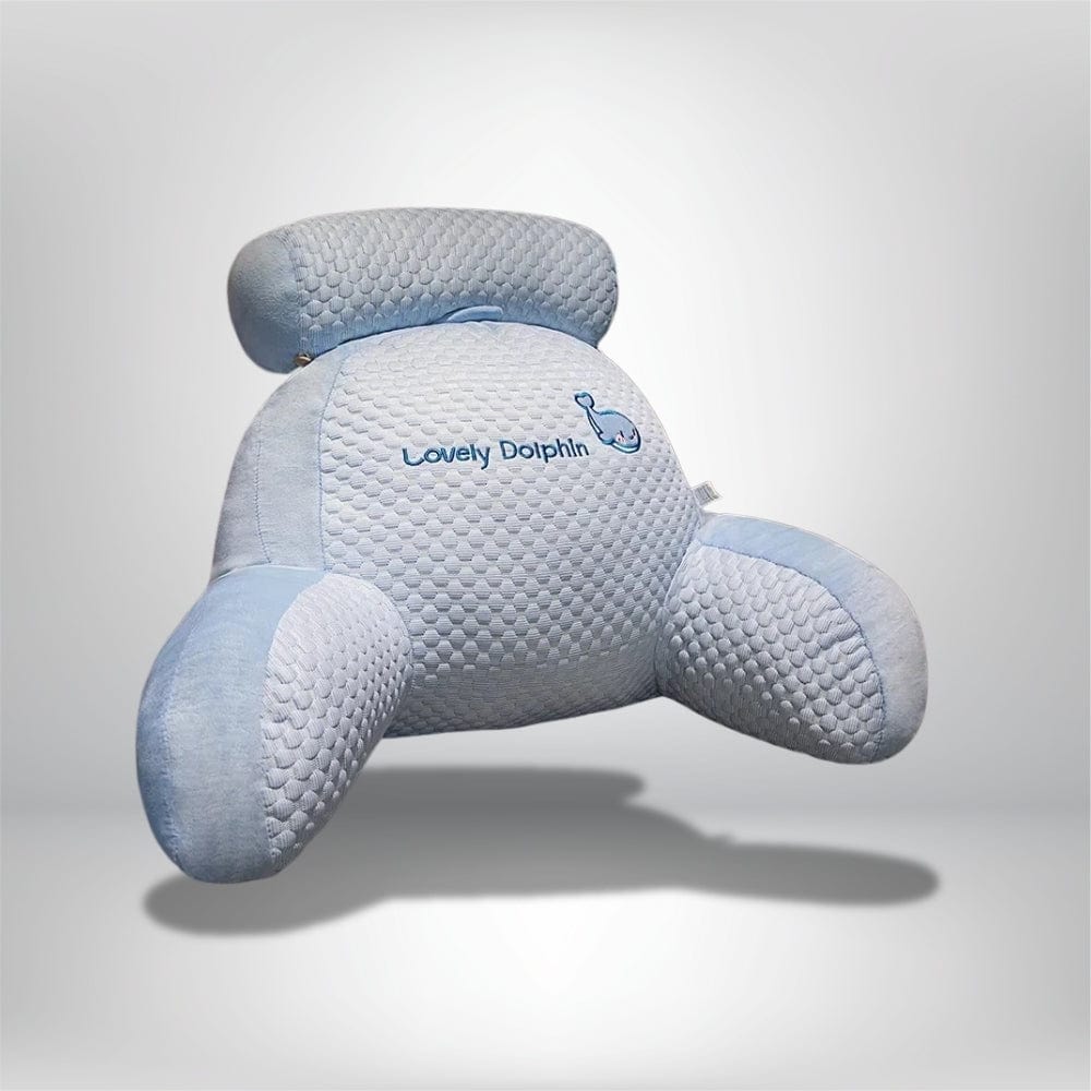 Coussin de lecture en forme de dauphin, en velours bleu, posé sur un fond neutre