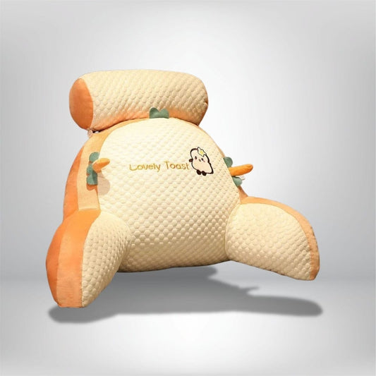 Coussin de lecture en forme de toast, aux couleurs crème et orange, posé sur un fond neutre