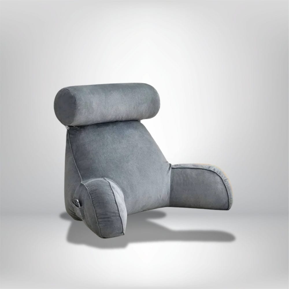 Coussin de lecture gris en velours, avec appui-tête, posé sur un fond neutre