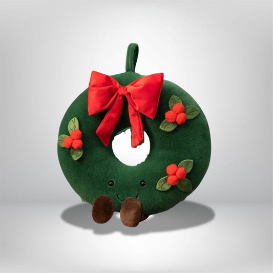 Coussin décoratif en forme de couronne verte avec un nœud rouge et des baies, idéal pour le salon