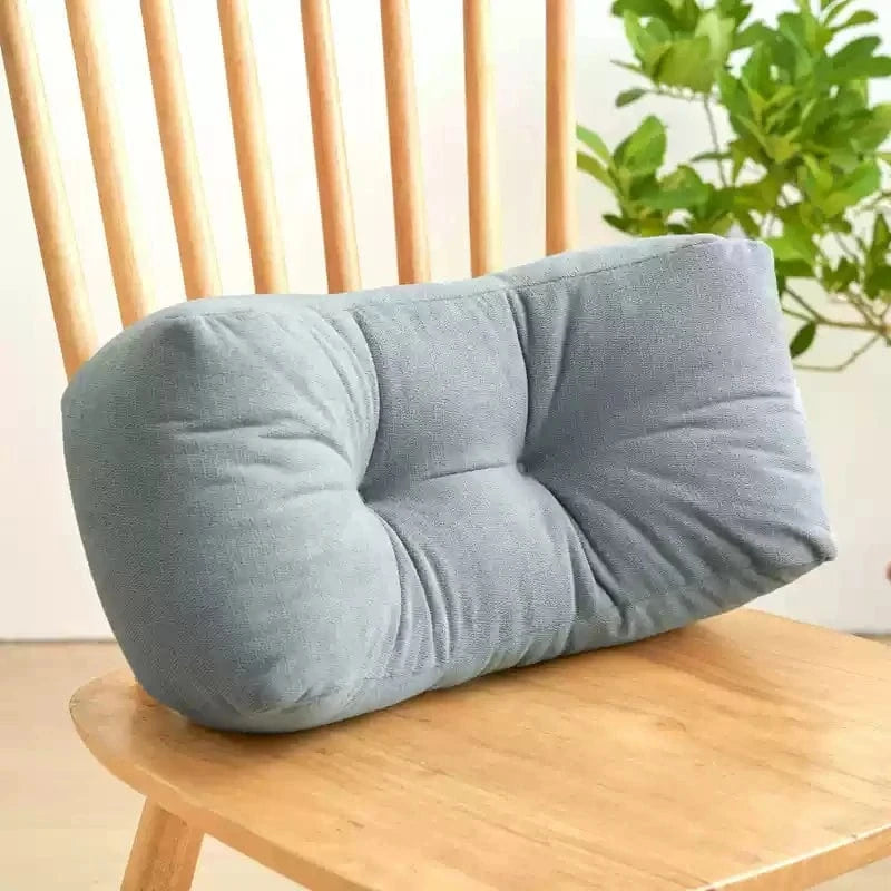 Coussin de sieste gris en tissu doux, posé sur une chaise en bois, avec un design confortable et arrondi